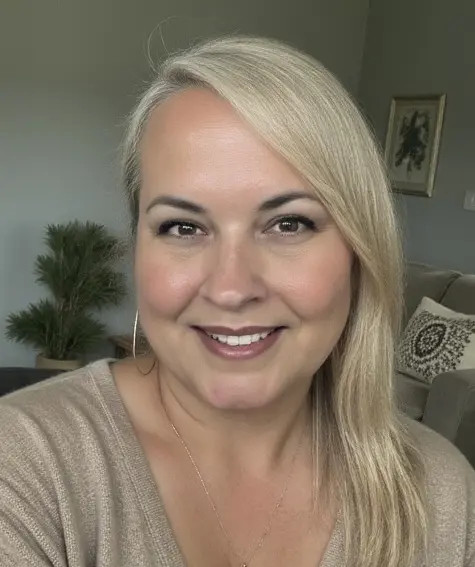85e2a641-3ccf-4c37-ad1d-431af56bbcbd_2 A woman with blonde hair and wearing a beige shirt.